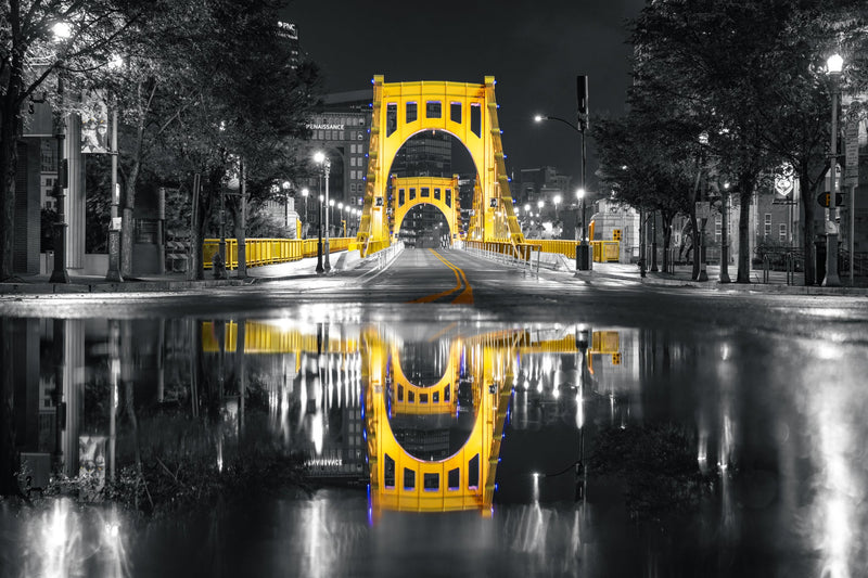 Photo of the Roberto Clemente Bridge in Pittsburgh, PA with the bridge in yellow color and rest of the photo in black and white.